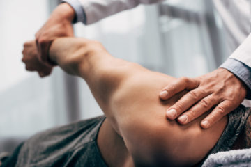 Focus of chiropractor stretching arm of patient.